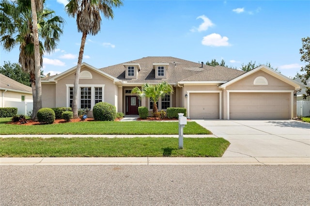 11845 Newberry Grove Loop, Riverview, FL 33579 - view of front of home with a garage, stucco siding, driveway, and roof with shingles