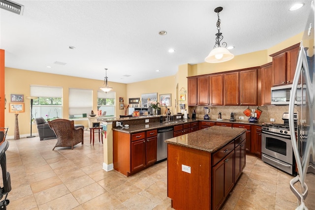 11845 Newberry Grove Loop, Riverview, FL 33579 - kitchen with appliances with stainless steel finishes, open floor plan, decorative backsplash, a peninsula, and recessed lighting