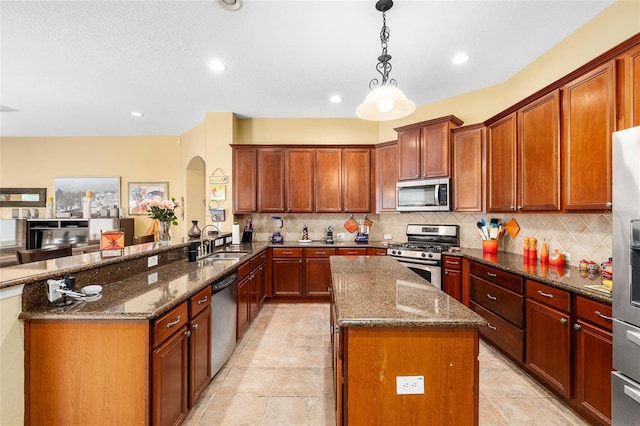 11845 Newberry Grove Loop, Riverview, FL 33579 - kitchen with appliances with stainless steel finishes, arched walkways, a sink, dark stone counters, and backsplash