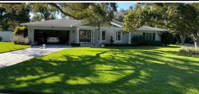 ranch-style house with an attached garage, a front yard, and concrete driveway