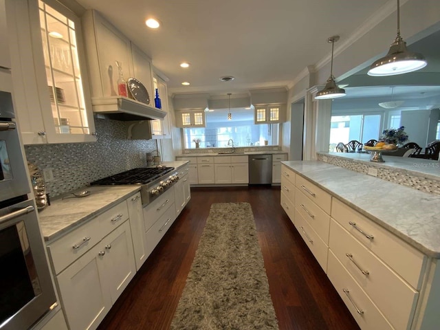 kitchen with backsplash, white cabinets, glass insert cabinets, ornamental molding, and stainless steel appliances