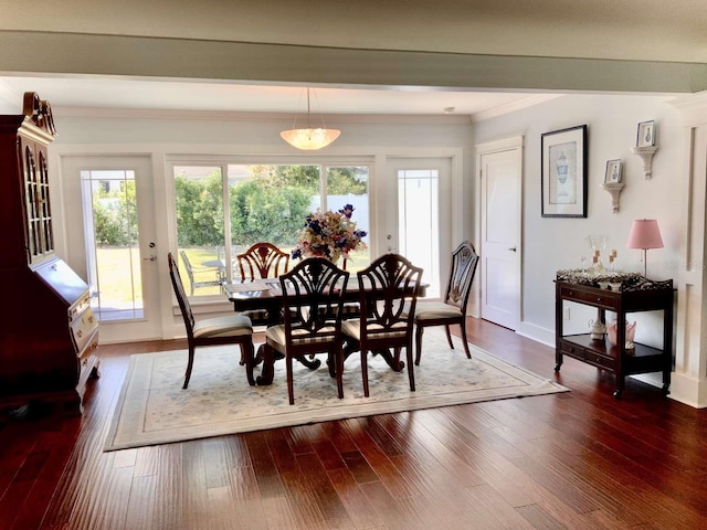 dining space featuring crown molding, baseboards, and dark wood-type flooring
