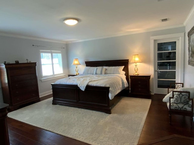bedroom featuring wood-type flooring, baseboards, visible vents, and ornamental molding