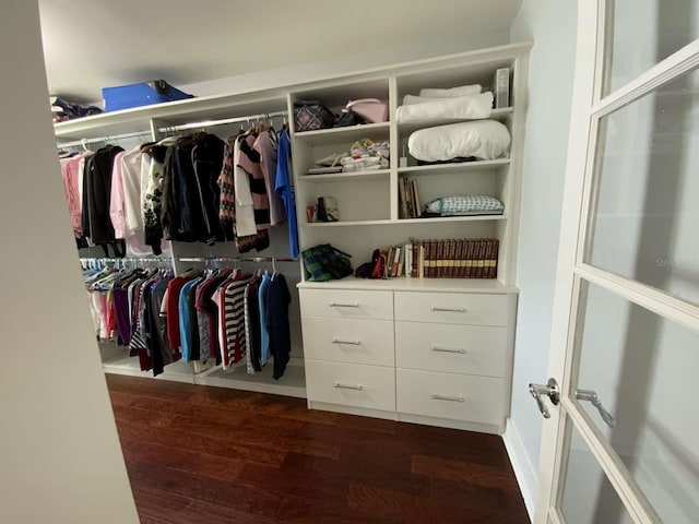 walk in closet with dark wood-style flooring