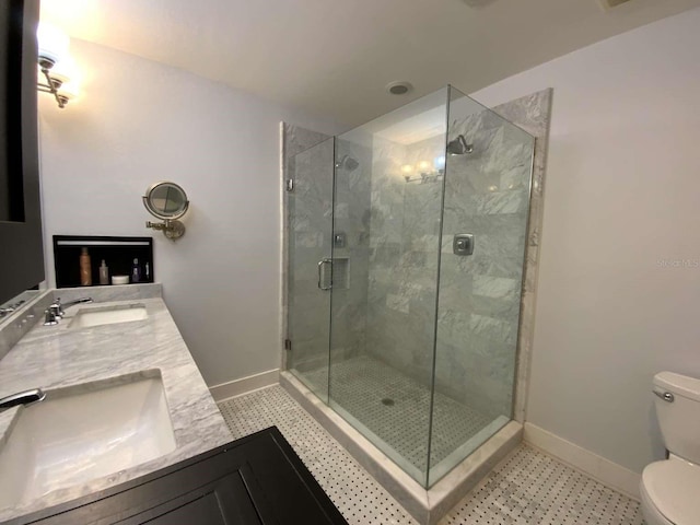 bathroom featuring baseboards, a sink, a stall shower, and toilet