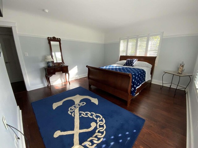 bedroom with baseboards and wood finished floors