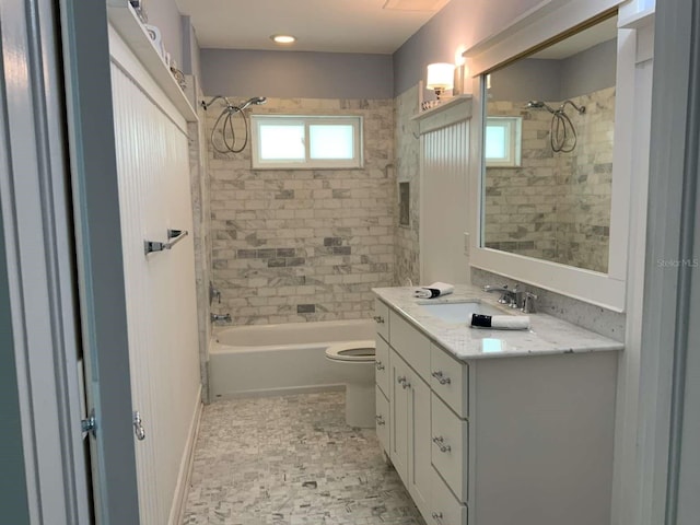bathroom featuring washtub / shower combination, vanity, and toilet