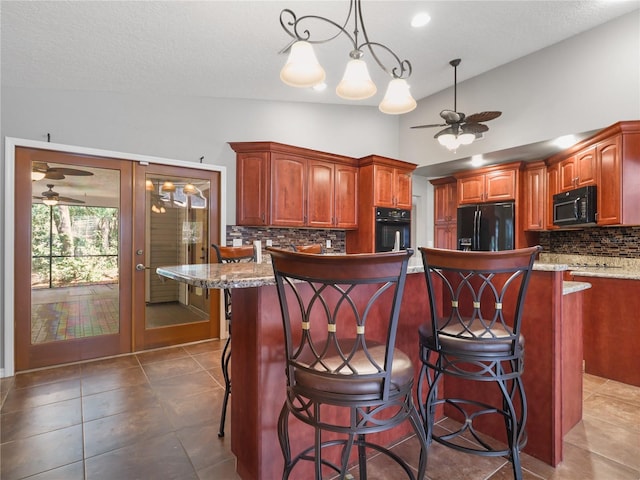kitchen with a ceiling fan, pendant lighting, a kitchen bar, backsplash, and black appliances