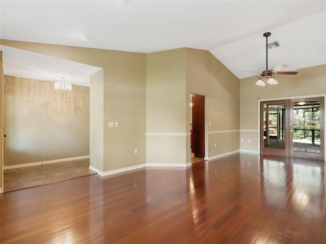 spare room with baseboards, wood finished floors, ceiling fan with notable chandelier, and high vaulted ceiling
