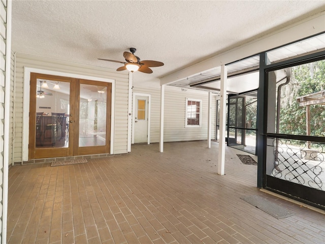 unfurnished sunroom featuring french doors and a ceiling fan