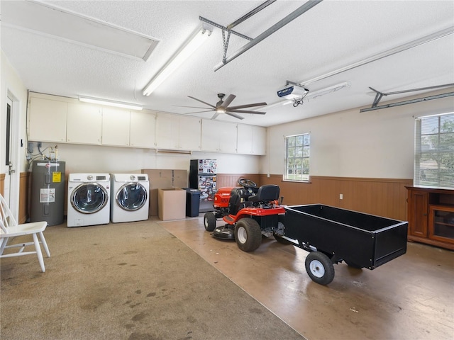 garage featuring separate washer and dryer, water heater, wainscoting, wooden walls, and a garage door opener