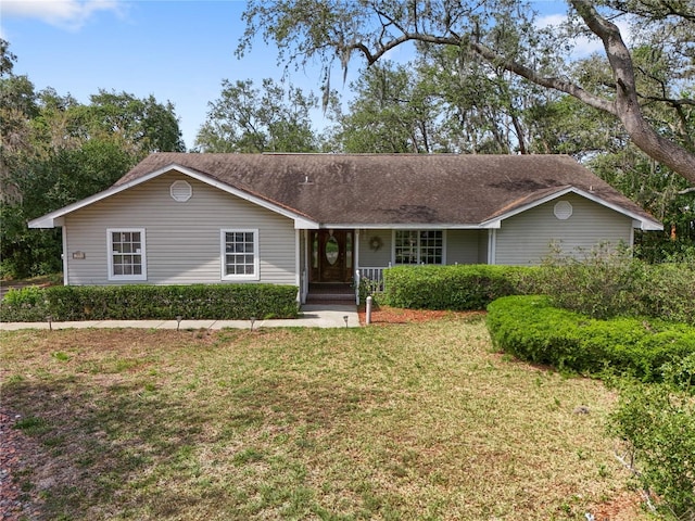 ranch-style home with covered porch and a front lawn