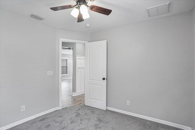 7031 Kendall Heath Way, Land O Lakes, FL 34637 - unfurnished bedroom featuring carpet, baseboards, and a ceiling fan