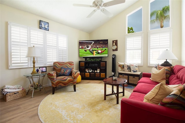 living area featuring plenty of natural light, wood finished floors, vaulted ceiling, and ceiling fan
