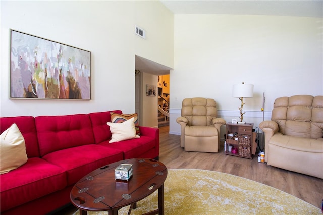 living area with wood finished floors and a high ceiling