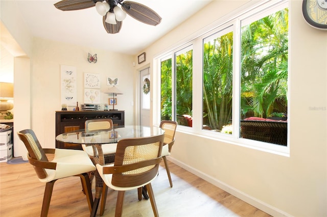 dining room featuring light wood finished floors, a ceiling fan, and baseboards