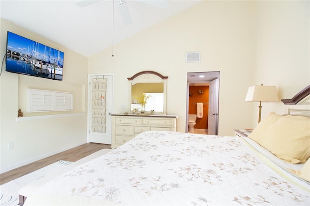 bedroom featuring high vaulted ceiling, wood finished floors, baseboards, ensuite bathroom, and ceiling fan