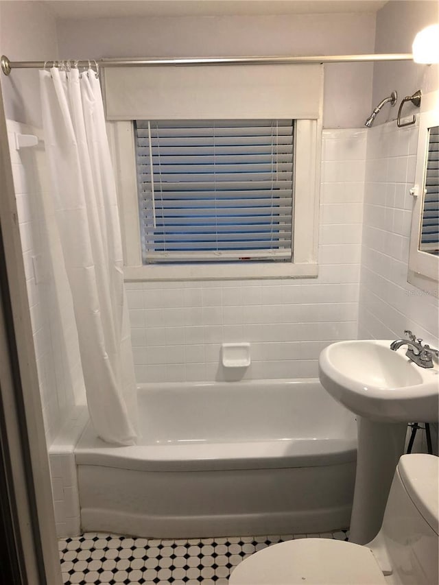 122 19th Ave N, Saint Petersburg, FL 33704 - bathroom featuring tile walls, shower / bathtub combination with curtain, and toilet