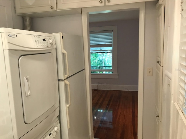 122 19th Ave N, Saint Petersburg, FL 33704 - laundry area with baseboards, stacked washer / drying machine, cabinet space, and wood finished floors