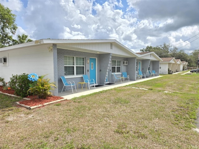 2210 Irene St, Lutz, FL 33549 - back of house with brick siding, a yard, and covered porch