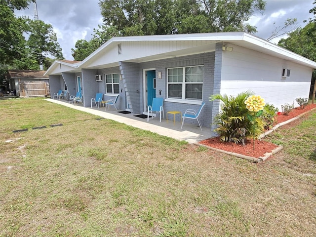 2210 Irene St, Lutz, FL 33549 - rear view of house featuring brick siding, a lawn, and covered porch