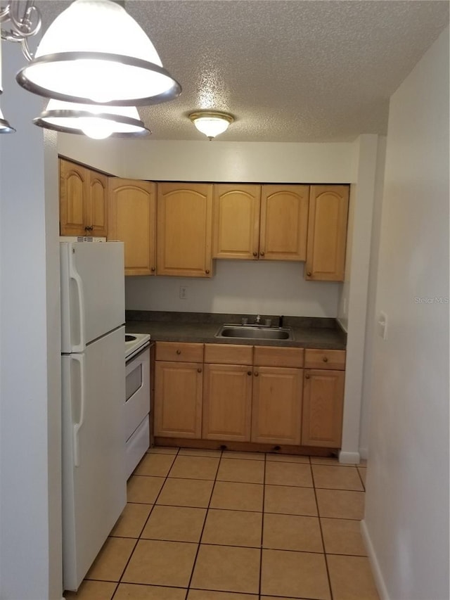2210 Irene St, Lutz, FL 33549 - kitchen featuring white appliances, a sink, dark countertops, light tile patterned flooring, and a textured ceiling