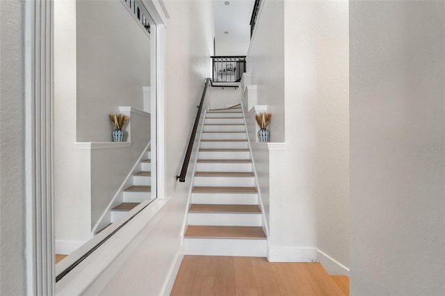 stairway featuring baseboards and wood finished floors
