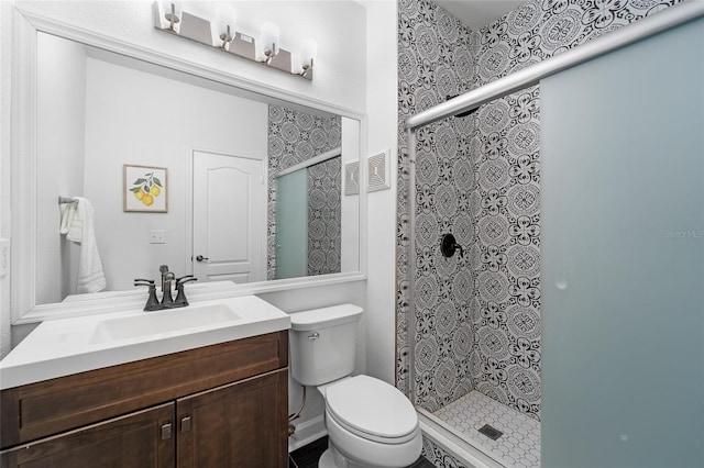 bathroom featuring vanity, a stall shower, and toilet