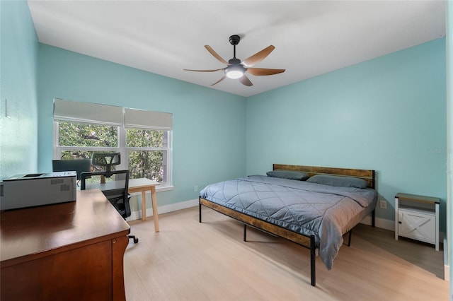 bedroom with baseboards, ceiling fan, and light wood-style flooring
