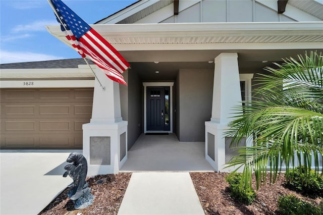 5828 Clairwood Ct, Palmetto, FL 34221 - property entrance with an attached garage, board and batten siding, and stucco siding