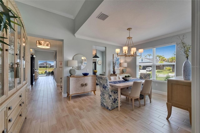 5828 Clairwood Ct, Palmetto, FL 34221 - dining space with baseboards, a chandelier, light wood-type flooring, and crown molding