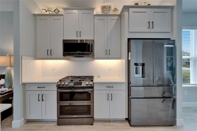 5828 Clairwood Ct, Palmetto, FL 34221 - kitchen with appliances with stainless steel finishes, light countertops, decorative backsplash, and plenty of natural light