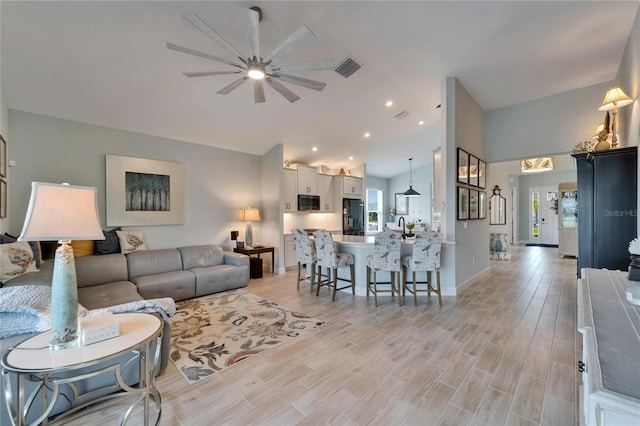 5828 Clairwood Ct, Palmetto, FL 34221 - living room with lofted ceiling, a ceiling fan, light wood finished floors, recessed lighting, and baseboards