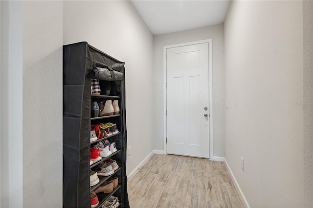doorway with baseboards and wood finished floors