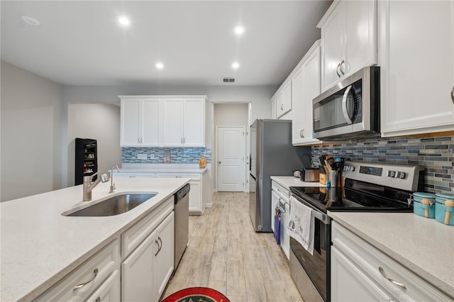 kitchen with white cabinets, appliances with stainless steel finishes, and a sink