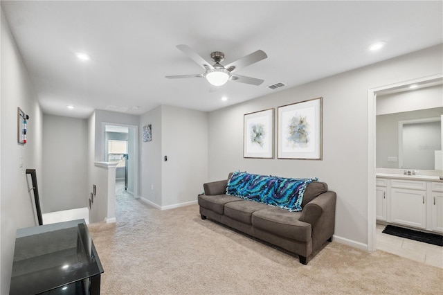 living room with light carpet, baseboards, a ceiling fan, and visible vents