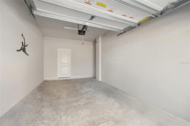 garage with concrete block wall and a garage door opener