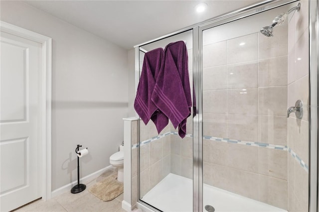 full bathroom featuring a stall shower, toilet, baseboards, and tile patterned floors