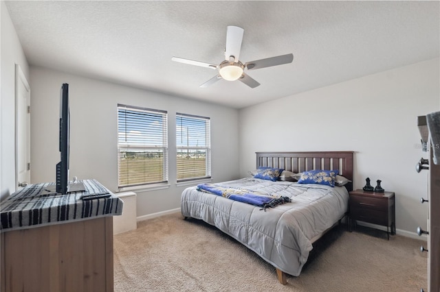 bedroom featuring baseboards, light carpet, and ceiling fan