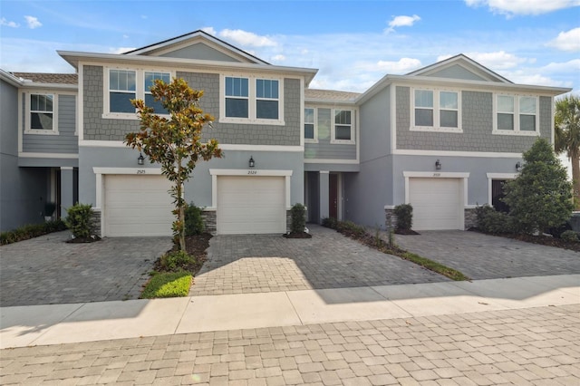 2529 Arbor Wind Dr, Lutz, FL 33558 - townhome / multi-family property with stucco siding, driveway, an attached garage, and stone siding