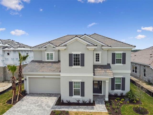 34084 Torrent Ln, Wesley Chapel, FL 33543 - traditional-style house with stucco siding, decorative driveway, an attached garage, and a tile roof