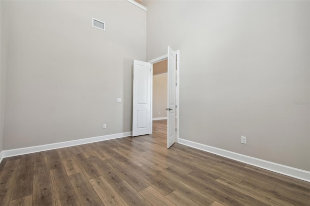 34084 Torrent Ln, Wesley Chapel, FL 33543 - spare room featuring dark wood-type flooring, baseboards, and a high ceiling