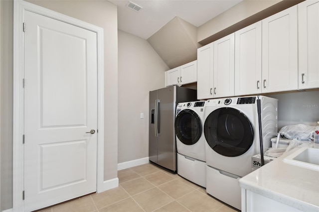 34084 Torrent Ln, Wesley Chapel, FL 33543 - laundry room featuring cabinet space, washing machine and dryer, light tile patterned floors, and baseboards