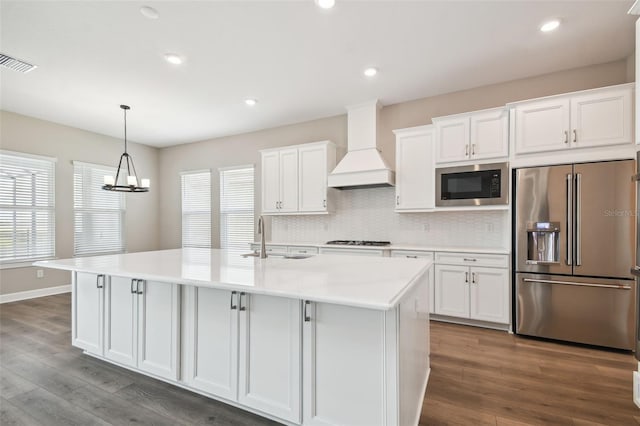 34084 Torrent Ln, Wesley Chapel, FL 33543 - kitchen featuring high end refrigerator, custom exhaust hood, built in microwave, a sink, and gas cooktop