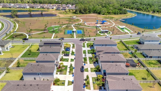drone / aerial view featuring a residential view, a water view, and a wooded view