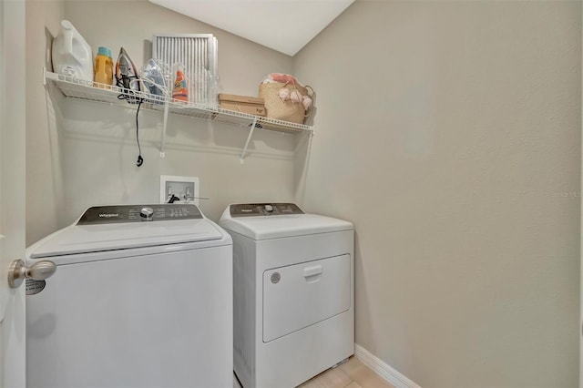washroom with baseboards, laundry area, and washer and clothes dryer