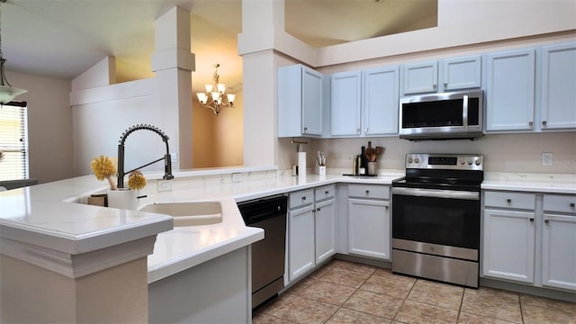 13653 Artesa Bell Dr, Riverview, FL 33579 - kitchen featuring stainless steel appliances, a sink, light countertops, a chandelier, and a peninsula