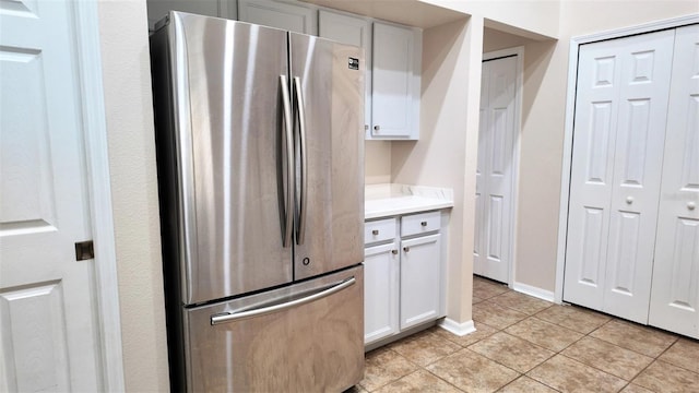 13653 Artesa Bell Dr, Riverview, FL 33579 - kitchen featuring freestanding refrigerator, light tile patterned floors, light countertops, and white cabinets
