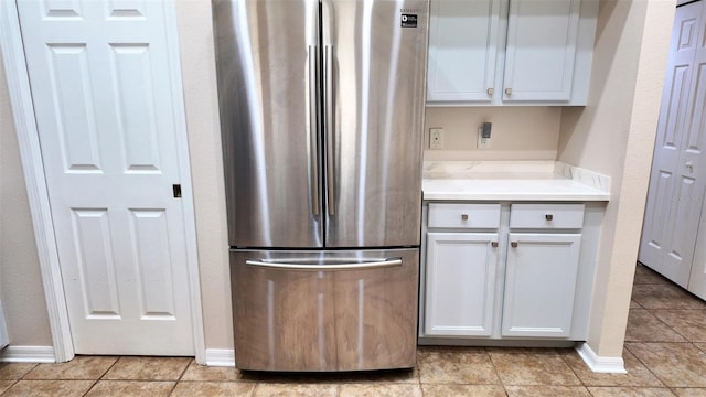 13653 Artesa Bell Dr, Riverview, FL 33579 - kitchen with freestanding refrigerator, white cabinetry, light tile patterned floors, and baseboards