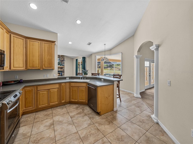 kitchen with a sink, a peninsula, arched walkways, appliances with stainless steel finishes, and ornate columns